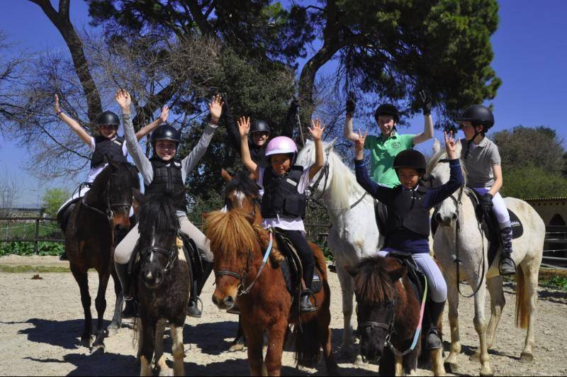 Alumnos de la escuela celebrando a caballo