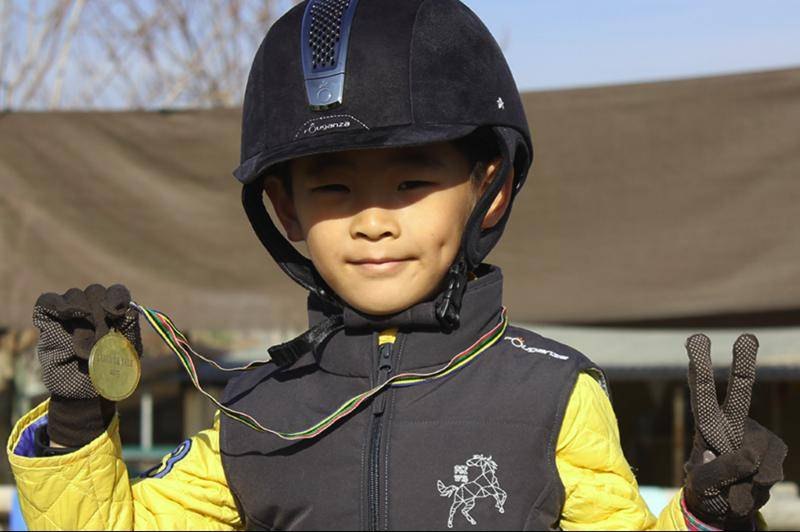 Niño con su medalla del campus