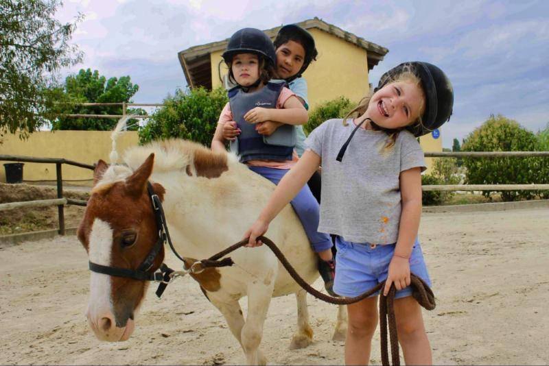Niñas sonriendo con su poni